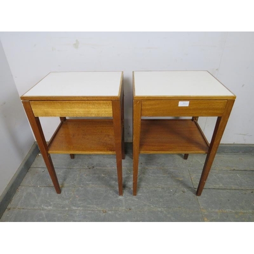 814 - A pair of mid-century teak two-tier side tables, the inset formica tops above blind drawers, on tape... 