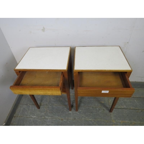 814 - A pair of mid-century teak two-tier side tables, the inset formica tops above blind drawers, on tape... 