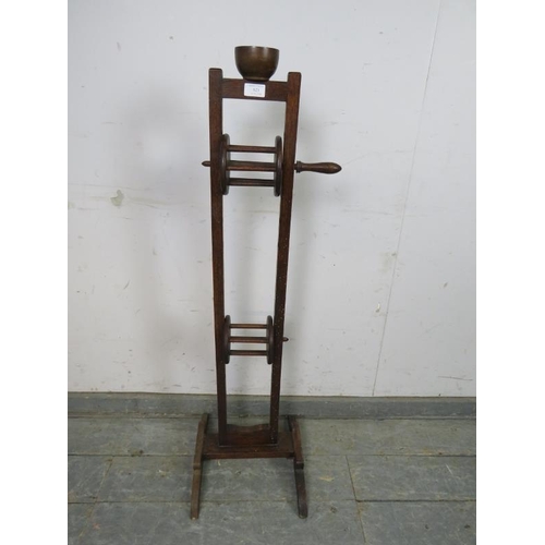 823 - A 19th century oak floor-standing wool winder, surmounted by a mahogany cup, above a height adjustab... 