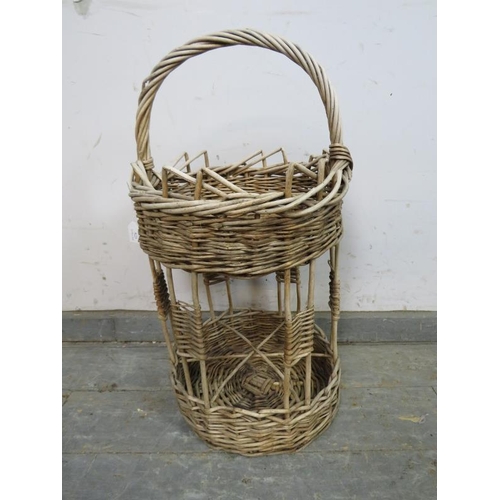 825 - A vintage French two-tier wicker picnic basket, the top section with woven gallery above a wine bott... 