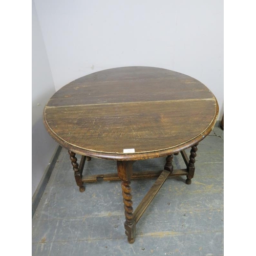 827 - An antique oak oval gate-leg table, on barley twist supports with stretchers. 
H72cm W102cm D47-133c... 