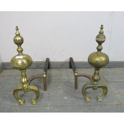 828 - A pair of large antique brass and cast-iron fire dogs, on curved supports. 
H50cm W17cm D62cm (appro... 