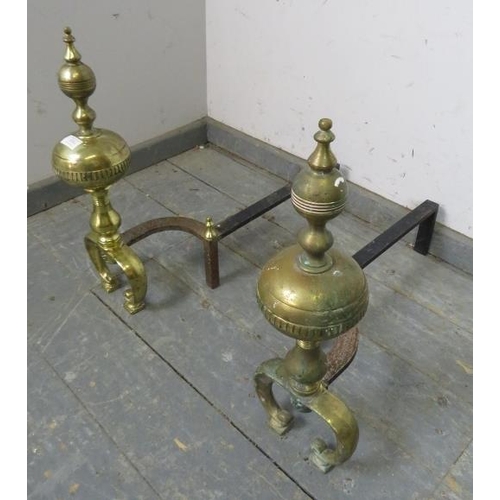 828 - A pair of large antique brass and cast-iron fire dogs, on curved supports. 
H50cm W17cm D62cm (appro... 