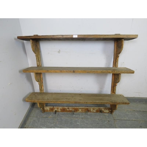 830 - A rustic Continental antique pine wall-mounting set of three open shelves with shaped brackets under... 