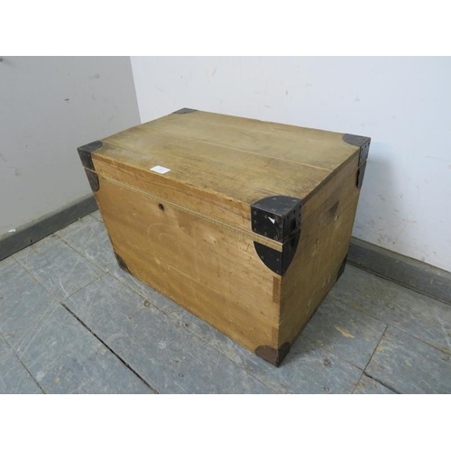 836 - A small vintage pine flat topped trunk, having metal bound corners and recessed handles to either si... 