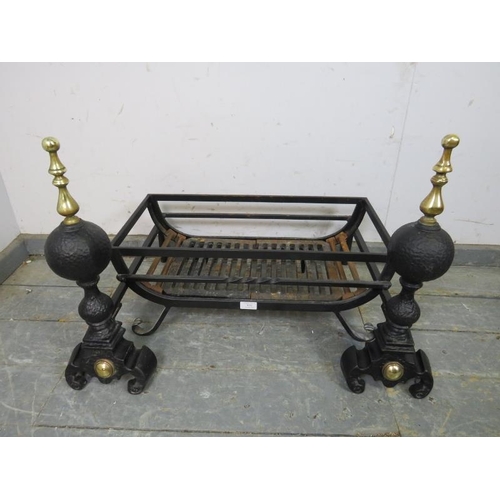 838 - A pair of antique style cast iron and brass fire dogs, together with a wrought iron fire basket, on ... 