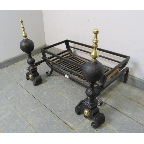 838 - A pair of antique style cast iron and brass fire dogs, together with a wrought iron fire basket, on ... 