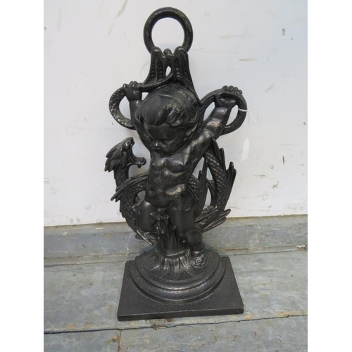 847 - An antique style cast iron doorstop in the form of a cherub holding a dragon. 
H45cm W22cm D12cm (ap... 