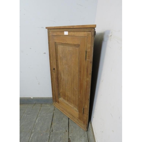 854 - An antique pine wall-hanging corner cupboard, the panelled door opening onto two loose shelves. 
H78... 