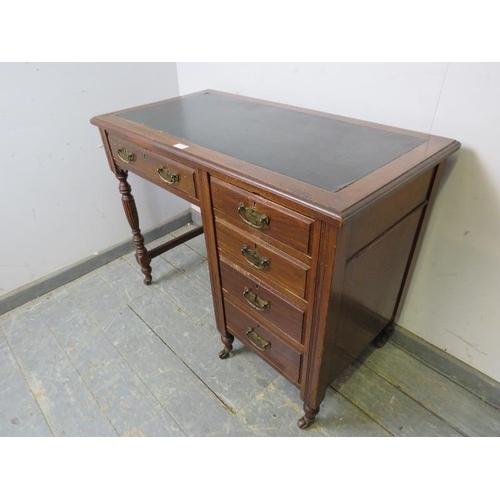 857 - An Edwardian mahogany kneehole desk, housing a configuration of five graduated oak-lined drawer with... 