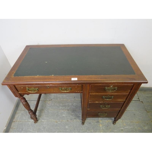 857 - An Edwardian mahogany kneehole desk, housing a configuration of five graduated oak-lined drawer with... 