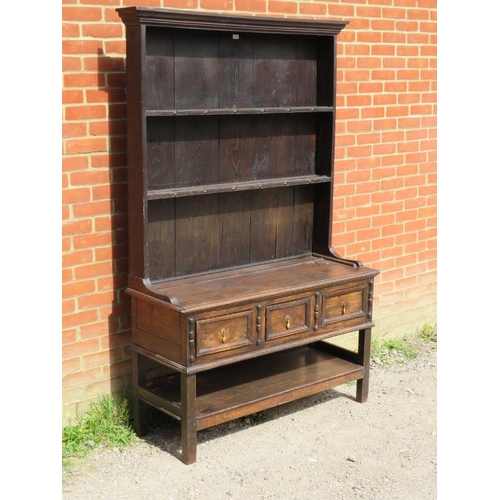 861 - A 19th century oak kitchen dresser in a 17th century taste, the moulded cornice above two open shelv... 