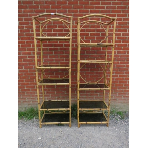 867 - A pair of tall vintage bamboo shelving units, each housing five smoked glass loose shelves. Original... 