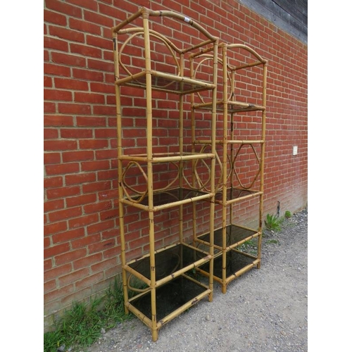 867 - A pair of tall vintage bamboo shelving units, each housing five smoked glass loose shelves. Original... 