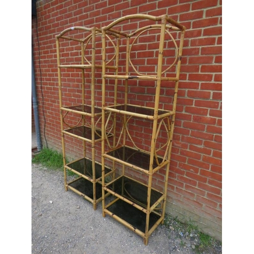 867 - A pair of tall vintage bamboo shelving units, each housing five smoked glass loose shelves. Original... 