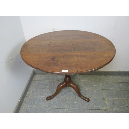 868 - A Georgian oak tilt-top circular supper table, on a tapered turned column with splayed tripod suppor... 