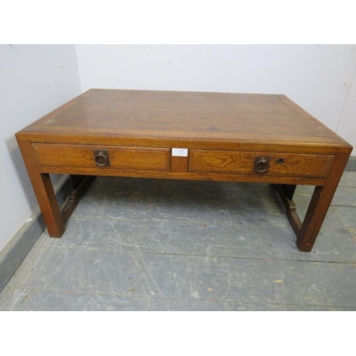 870 - A vintage Japanese elm low coffee table, the crossbanded top above two short drawers with brass drop... 