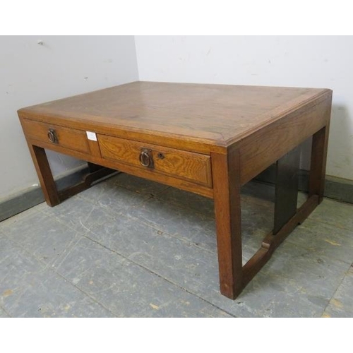 870 - A vintage Japanese elm low coffee table, the crossbanded top above two short drawers with brass drop... 