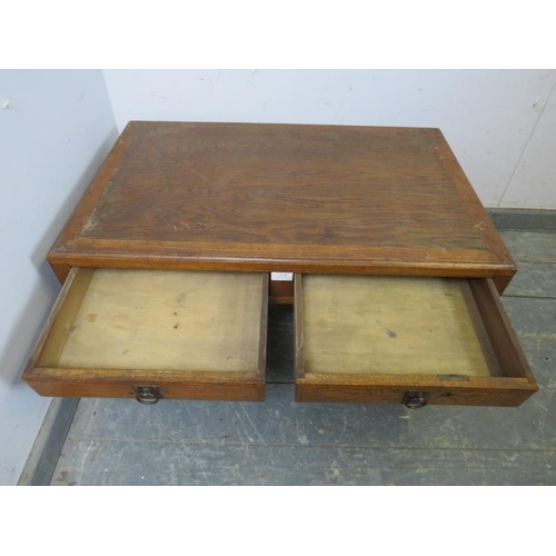 870 - A vintage Japanese elm low coffee table, the crossbanded top above two short drawers with brass drop... 