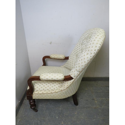 872 - A Victorian mahogany open-sided button backed armchair, upholstered in patterned cream material, on ... 