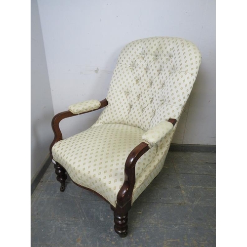 872 - A Victorian mahogany open-sided button backed armchair, upholstered in patterned cream material, on ... 