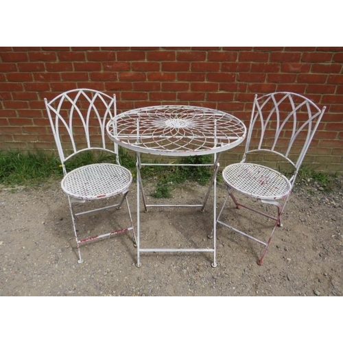 893 - A steel garden set painted white comprising a circular folding table with radial wirework decoration... 