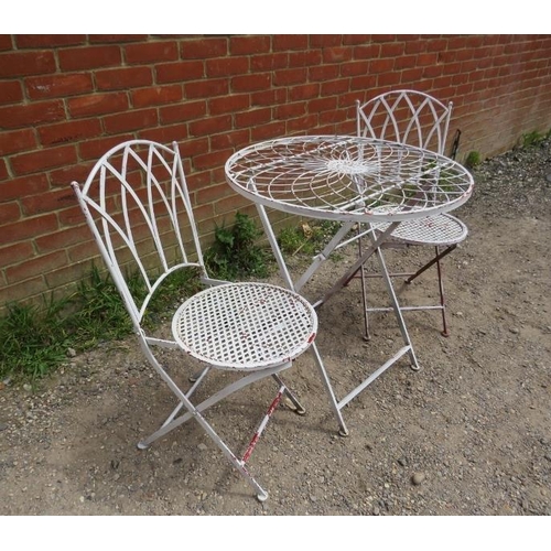 893 - A steel garden set painted white comprising a circular folding table with radial wirework decoration... 