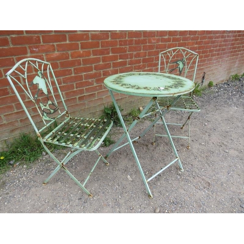 894 - A vintage steel garden set painted green comprising a circular folding table with pierced swallow de... 