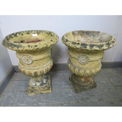 900 - A pair of weathered terracotta garden urn planters, having egg and dart moulding and fluted decorati... 