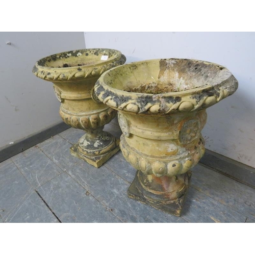 900 - A pair of weathered terracotta garden urn planters, having egg and dart moulding and fluted decorati... 