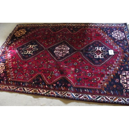 904 - A fine South West Persian Qashqai rug.  Three centred triangle motifs on red ground.  240cm x 165cm ... 