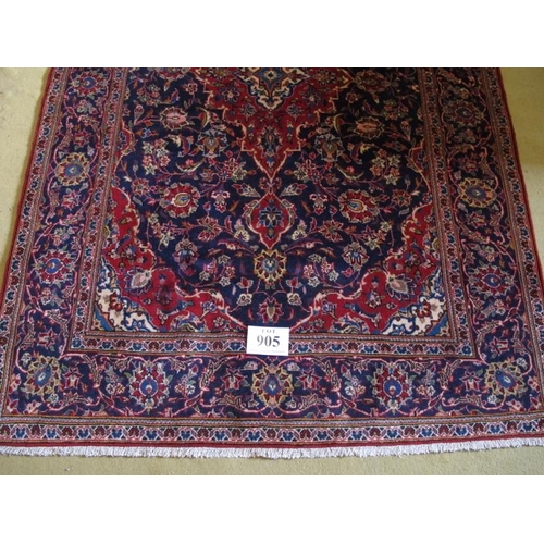 905 - A central Persian Kashan rug. Typical Kashan with central motif.  Red on blue ground.  230cm x 148cm... 