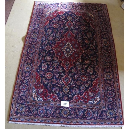 905 - A central Persian Kashan rug. Typical Kashan with central motif.  Red on blue ground.  230cm x 148cm... 