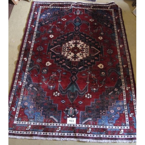 911 - South West Persian Afshar rug with a large central motif on red ground highlighted with blue, cream,... 