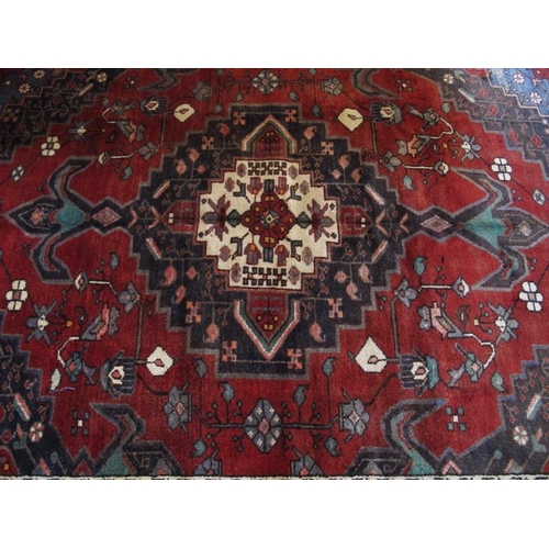 911 - South West Persian Afshar rug with a large central motif on red ground highlighted with blue, cream,... 