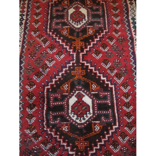 923 - A mid 20th Century Turkish runner.  Five central interlocking medallions on a red ground 290 x 81cms... 