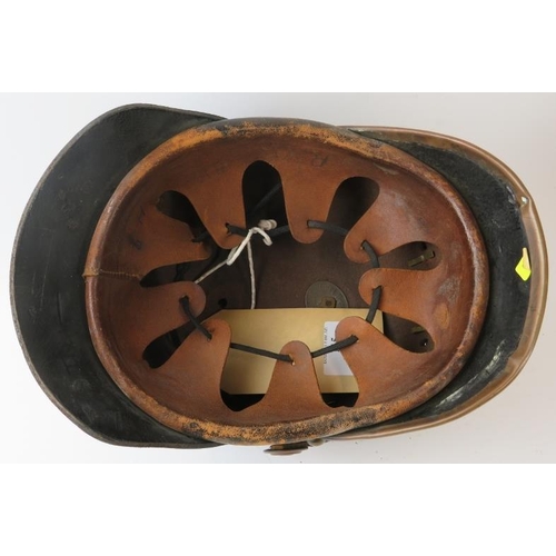 115 - A late 19th/early 20th century German Eschede Fire Brigade leather fire helmet with brass mounts, la... 