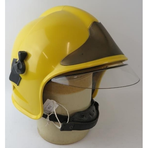 116 - A 1985 CGF Gallet yellow ABS fire helmet with integrated reflective gold visor and brass helmet moun... 