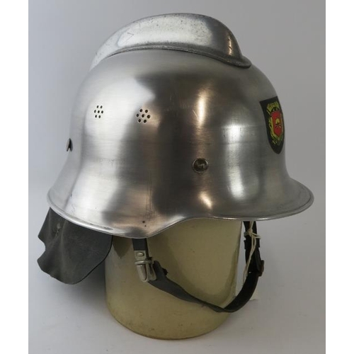 14 - A 1980s Dutch Fire Service polished steel fire helmet with leather neck cowl.