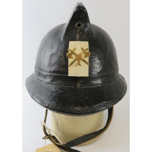 15 - A 1970s Belgian Fire Service black cork fire helmet with brass badge.