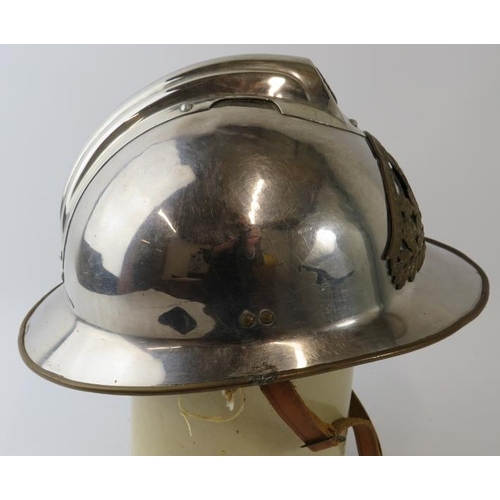 31 - A 1980s French Paris Fire Service polished chrome fire helmet with brass mounts