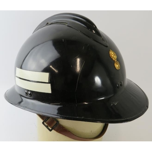 35 - A 1970s Luxumberg Fire Service black steel fire helmet  with brass badge.