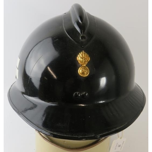 35 - A 1970s Luxumberg Fire Service black steel fire helmet  with brass badge.