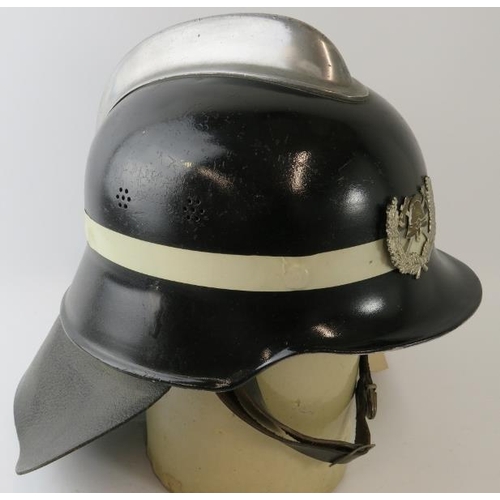 38 - An unusual 1970s German pattern Spanish Fire Service black fire helmet with polished metal comb and ... 