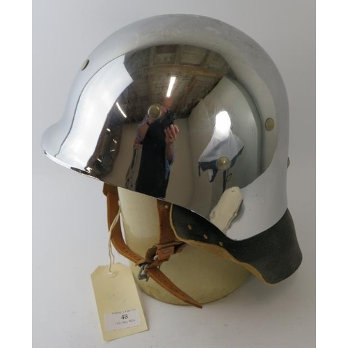 48 - A 1980s West German polished chrome fibreglass fire helmet with leather neck cowl