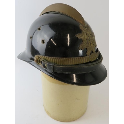 49 - A 1980s Brazilian Fire Service black fireglass fire helmet with brass mounts