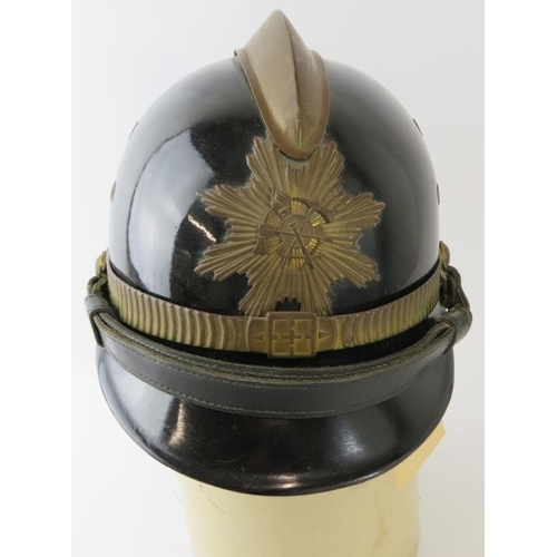 49 - A 1980s Brazilian Fire Service black fireglass fire helmet with brass mounts