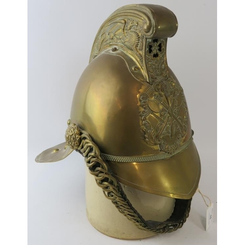 50 - An early 20th century British brass Merryweather fire helmet with chin strap.