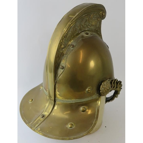 50 - An early 20th century British brass Merryweather fire helmet with chin strap.