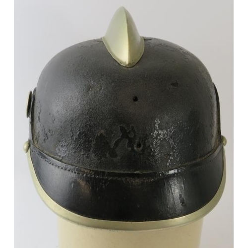 59 - An early 20th century German black leather fire helmet with white metal mounts